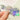 Holographic sticker reads "Feelings Club". Closeup of woman's hand with nude nailpolish holding sticker reflecting the light
