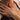 A close-up shot of a white woman aged 30-45, holding her left hand over her heart